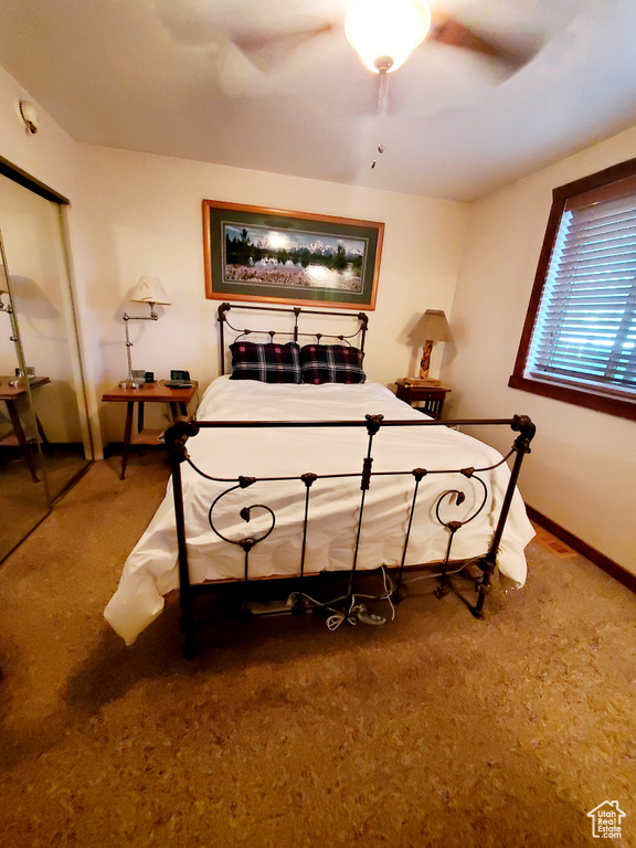 Carpeted bedroom with baseboards, a ceiling fan, and a closet
