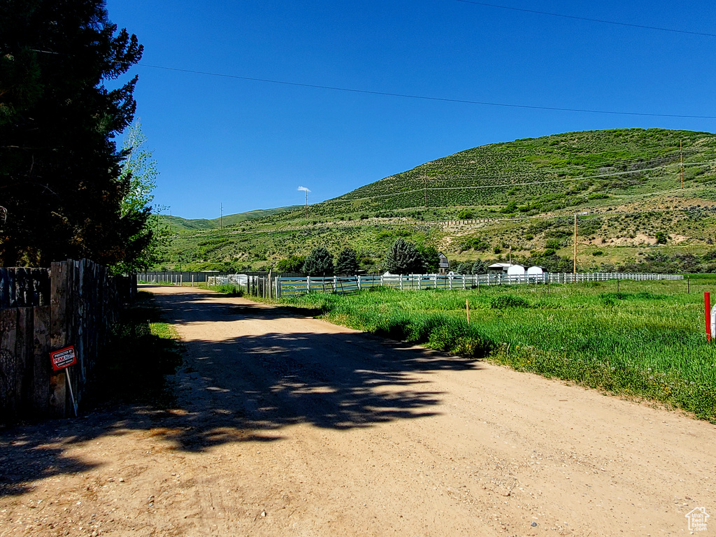 View of dirt / gravel road with a mountain view and a view of countryside