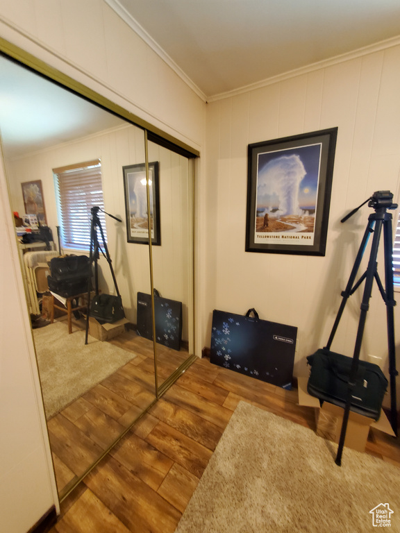 Workout room with wood finished floors and crown molding