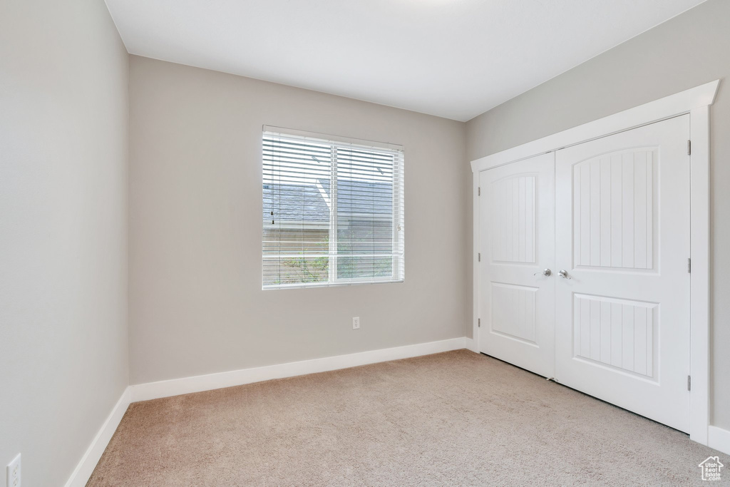 Unfurnished bedroom with carpet, baseboards, and a closet