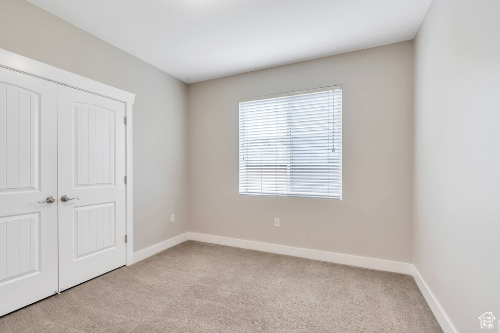 Unfurnished bedroom featuring carpet floors, baseboards, and a closet