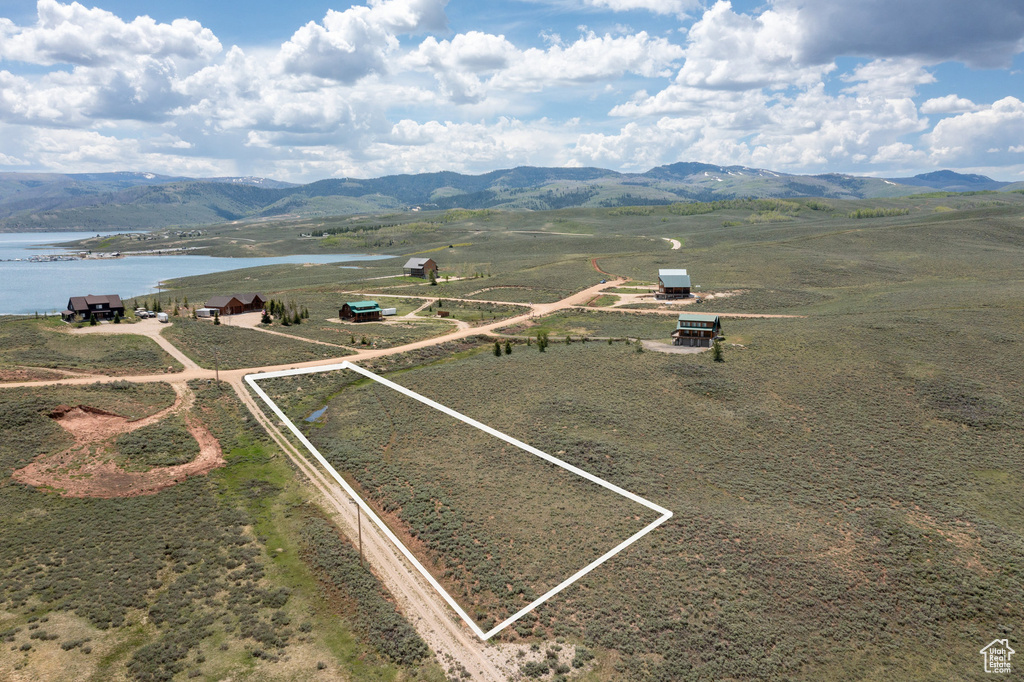 Aerial view of sparsely populated area with a water and mountain view and property parcel outlined
