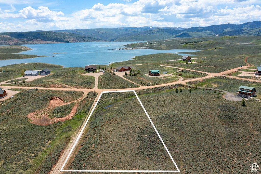 Aerial view of property and surrounding area featuring a water and mountain view and property boundaries highlighted