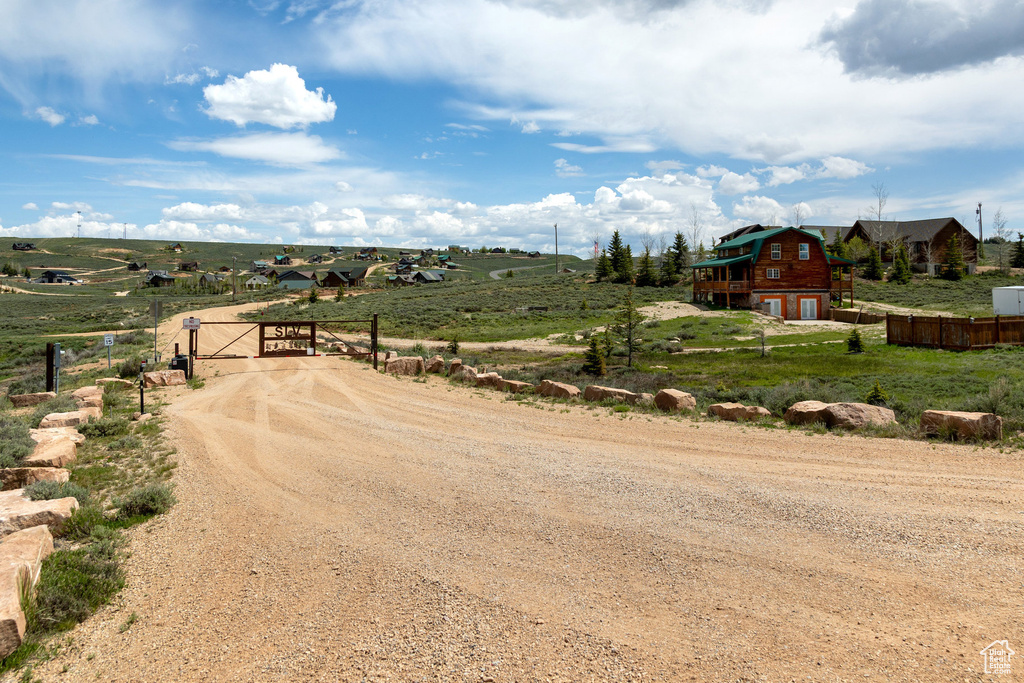 View of dirt / gravel driveway with a view of rural / pastoral area and a gated entry