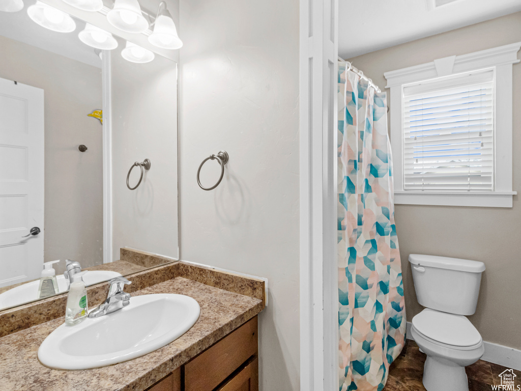 Bathroom featuring vanity, toilet, and a shower with curtain