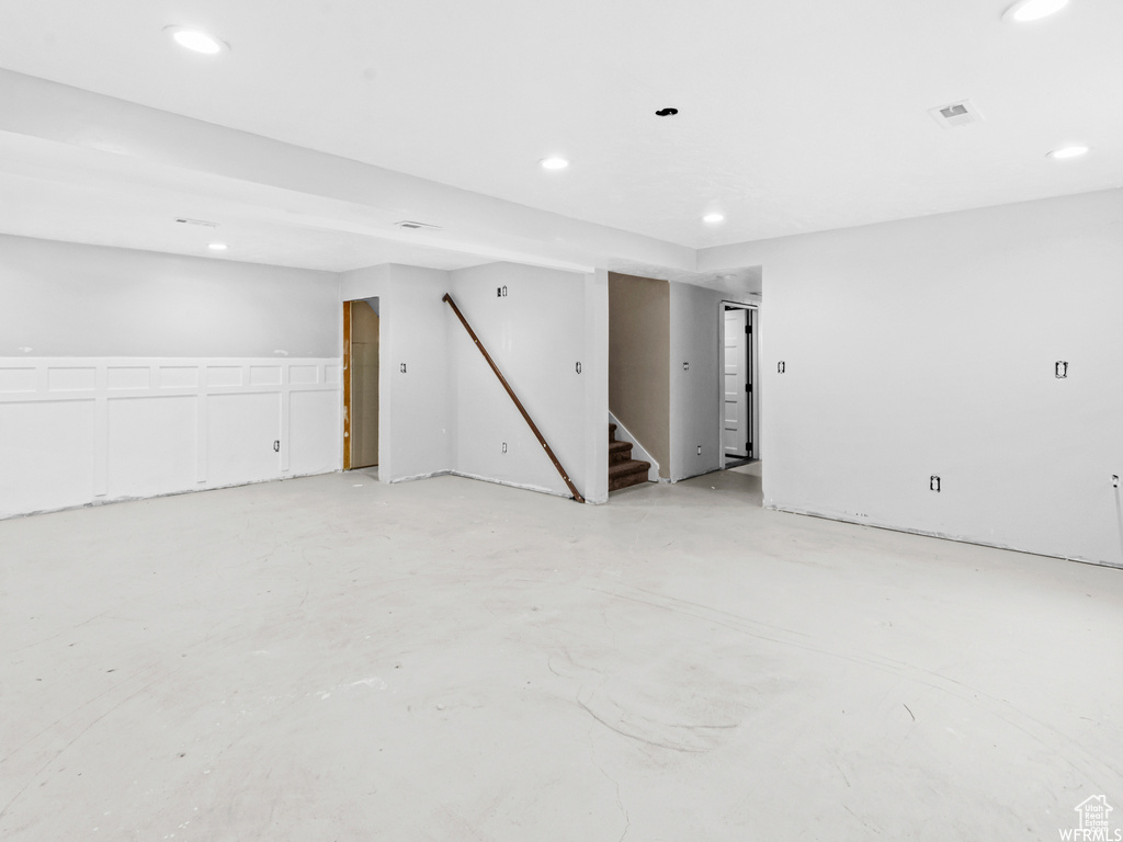 Unfurnished room featuring stairway, recessed lighting, and concrete flooring