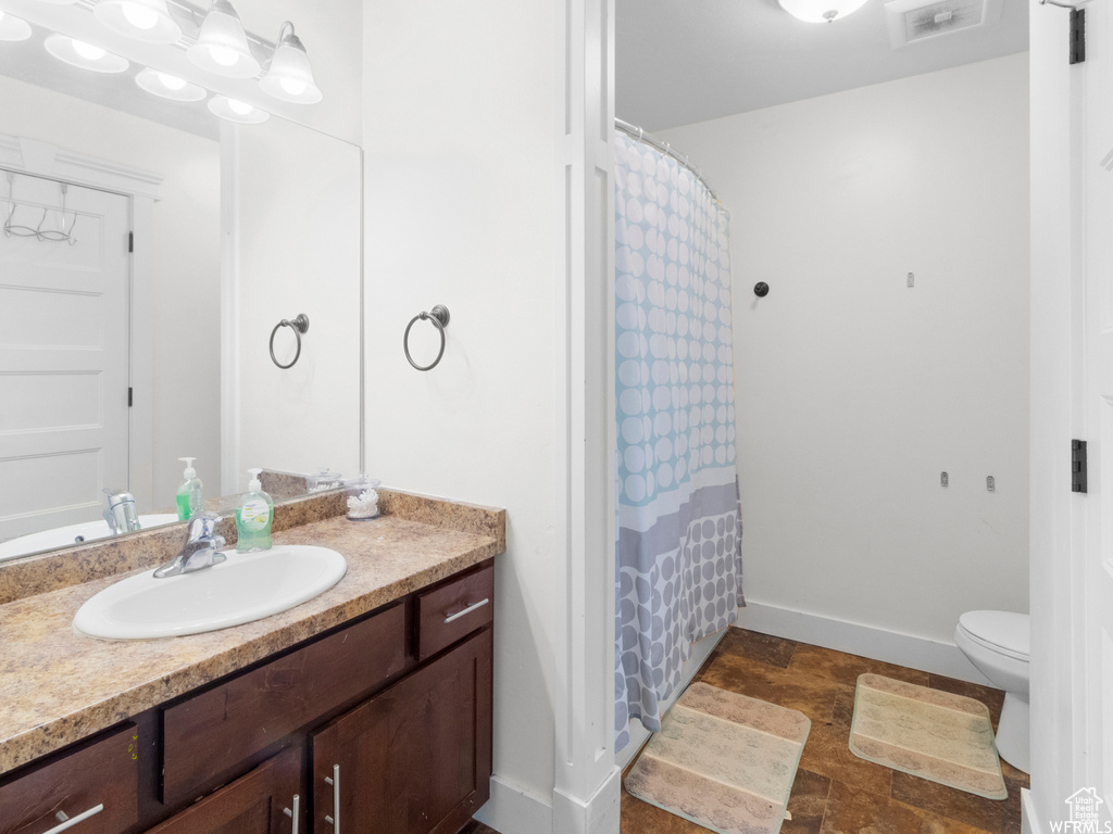 Full bathroom featuring vanity, toilet, baseboards, and a shower with curtain