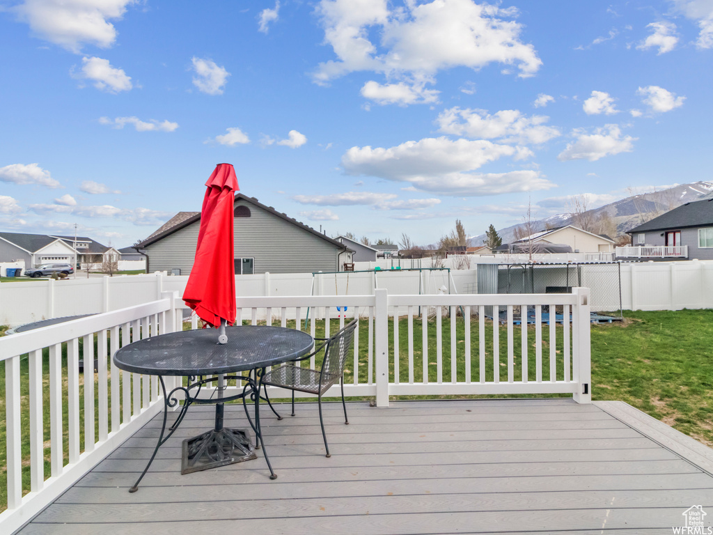 Wooden deck featuring outdoor dining space and a residential view