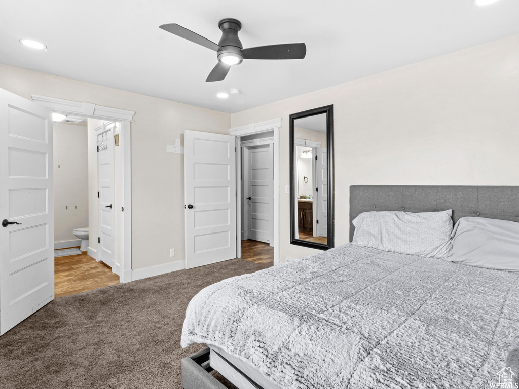 Carpeted bedroom featuring ensuite bath, baseboards, and a ceiling fan