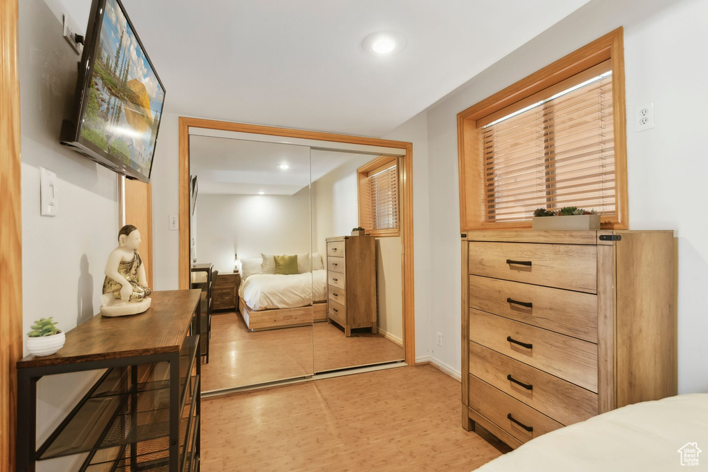Bedroom with a closet, light wood finished floors, recessed lighting, and baseboards