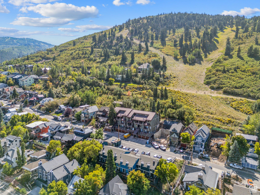 Aerial perspective of suburban area with mountains and a heavily wooded area
