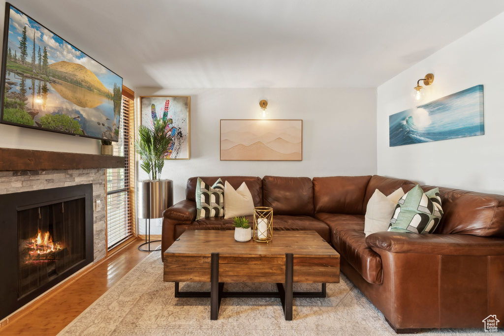 Living room with light wood-style flooring and a stone fireplace