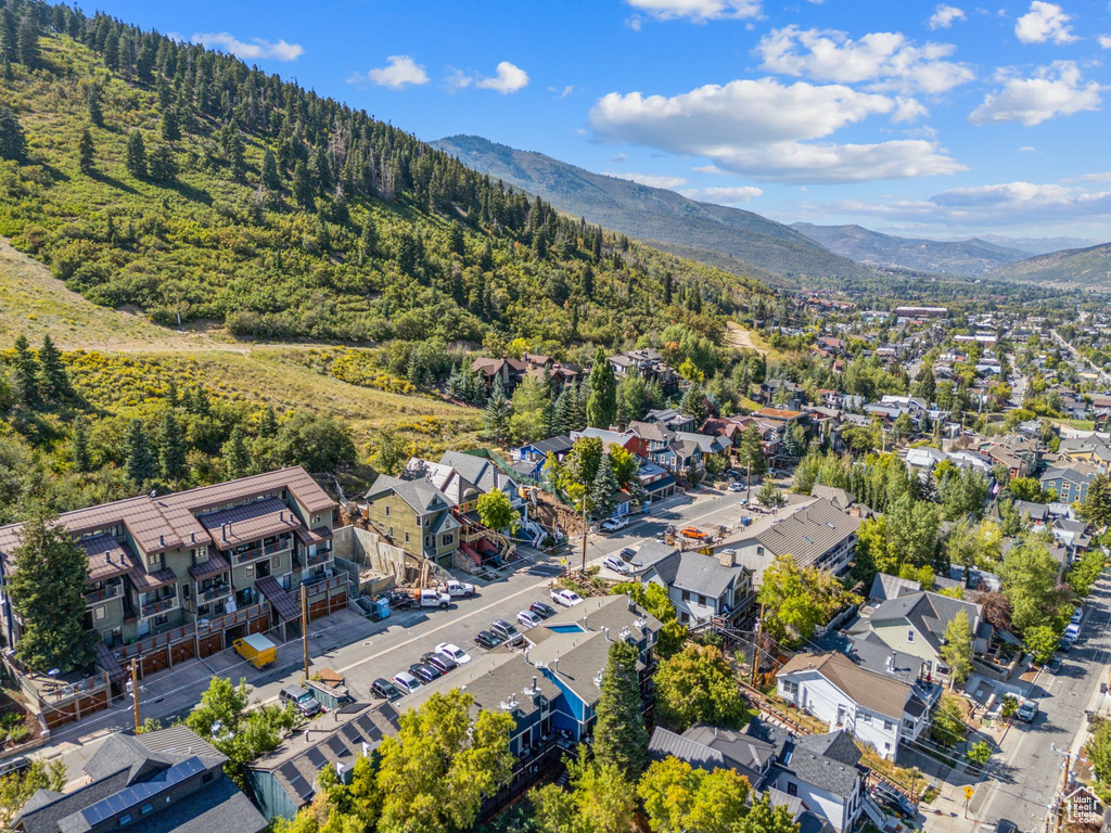 Aerial view of residential area featuring mountains and a forest