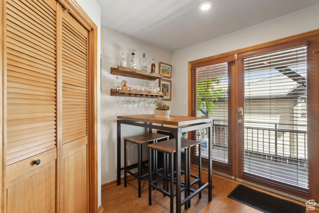 Dining area with light wood-style floors, a dry bar, and baseboards