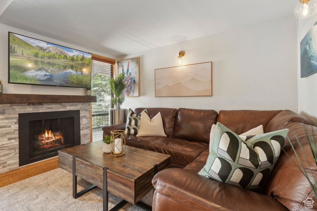 Living area featuring wood finished floors and a stone fireplace