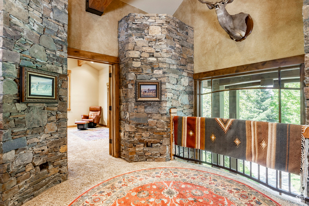 Carpeted living area featuring a towering ceiling