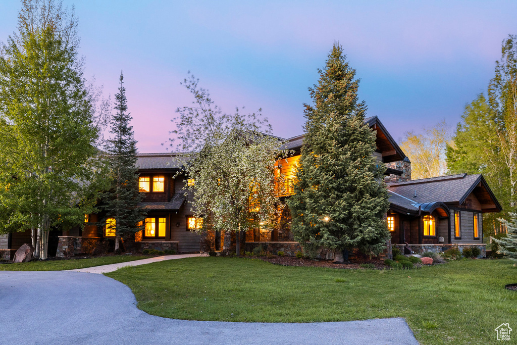 View of front of house with a yard and stone siding