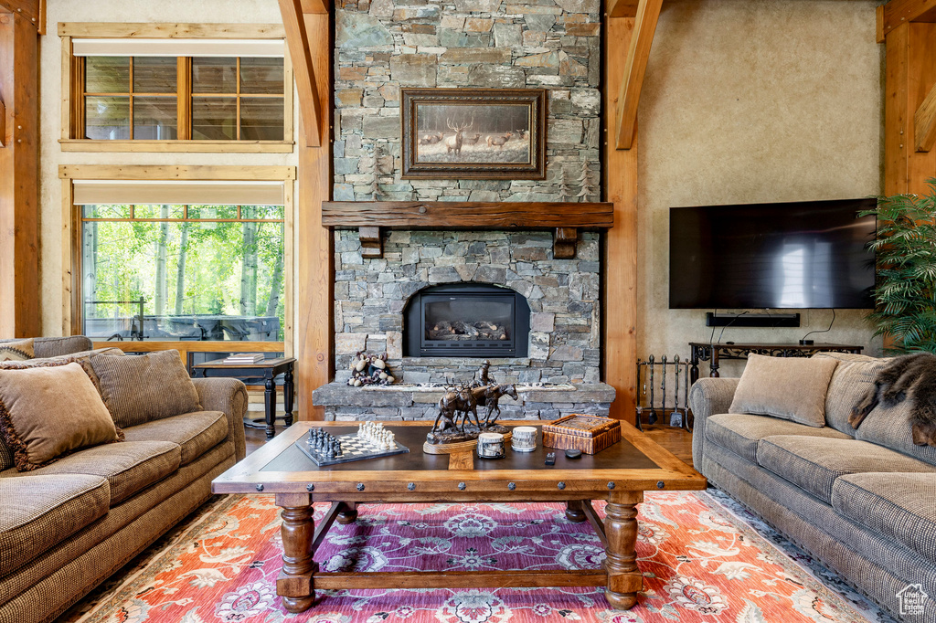 Living room with a stone fireplace and wood finished floors