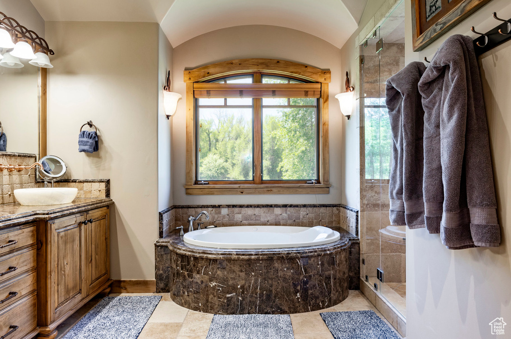 Full bathroom featuring vanity, a garden tub, tasteful backsplash, and a tile shower