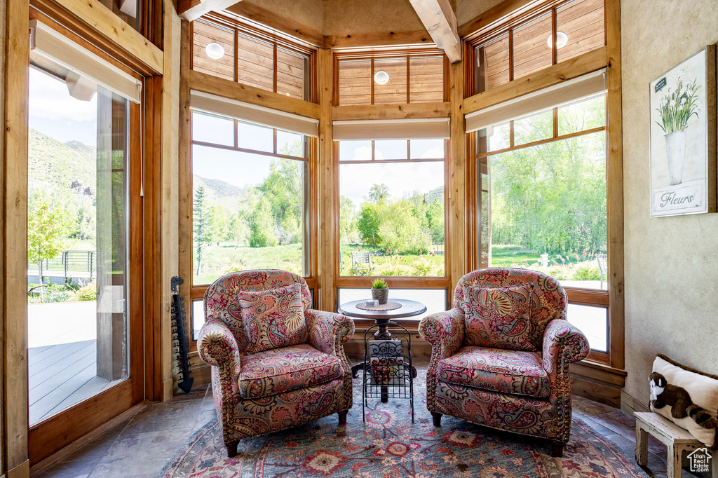 Sunroom / solarium with stone tile flooring and a mountain view
