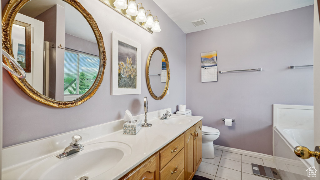 Bathroom featuring double vanity, toilet, a bath, tile patterned flooring, and baseboards