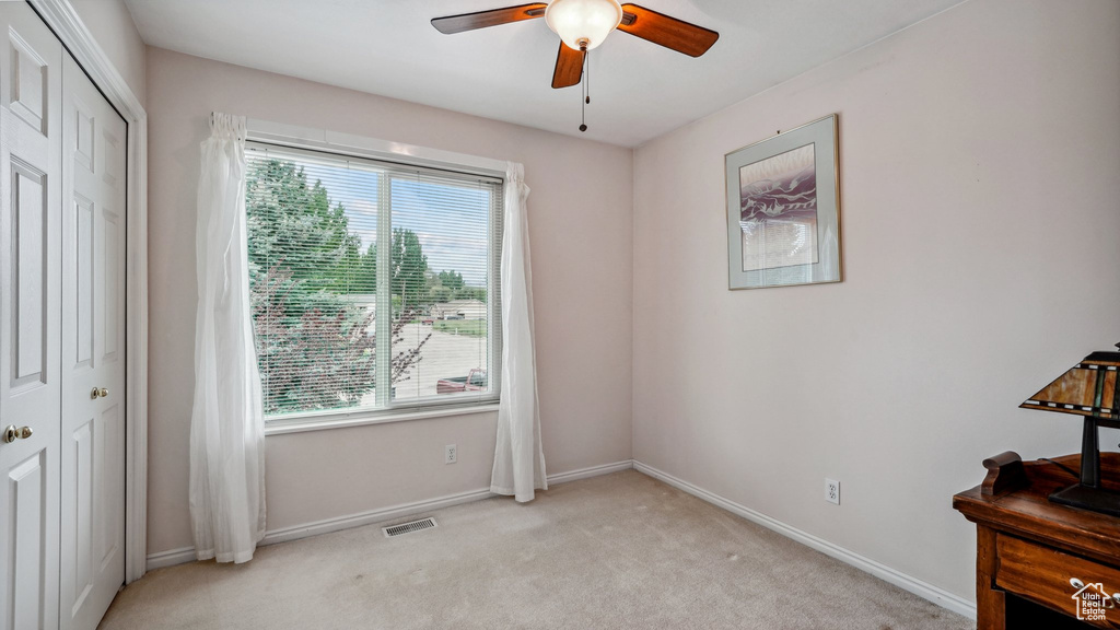 Unfurnished bedroom featuring multiple windows, light carpet, a closet, and baseboards