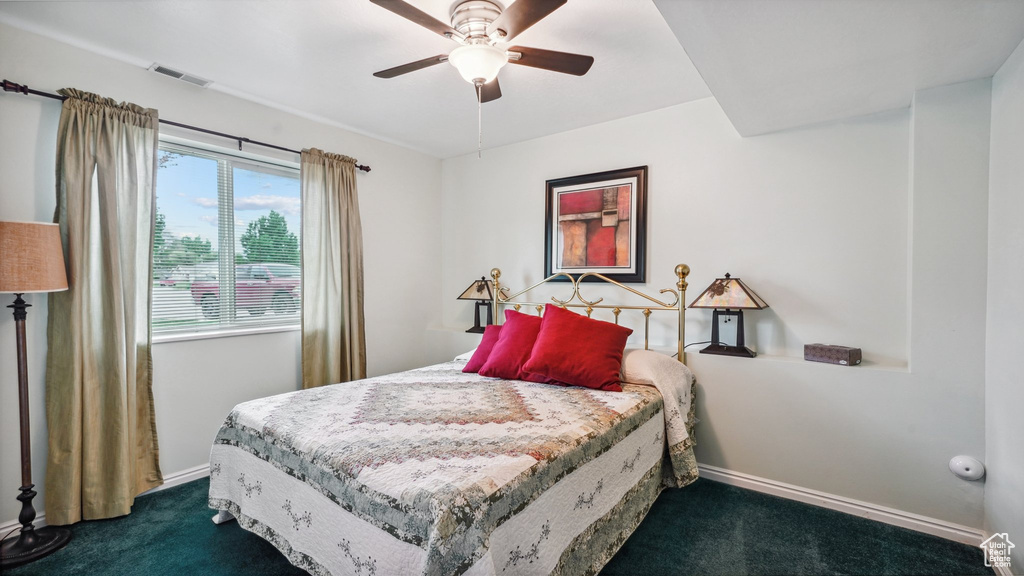 Bedroom with dark carpet, baseboards, and a ceiling fan