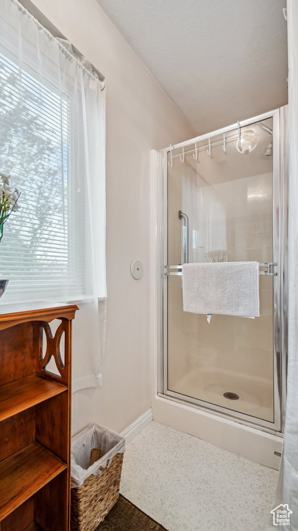 Bathroom with a shower stall and baseboards