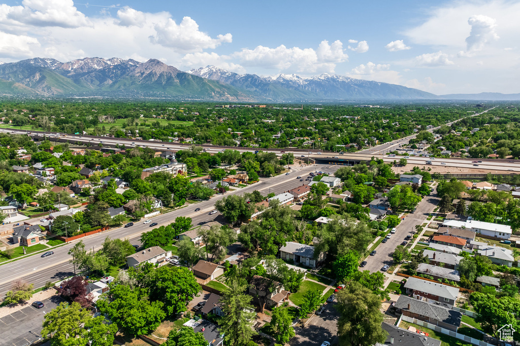 Aerial view of residential area featuring mountains and a major roadway
