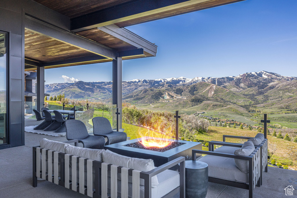 View of patio featuring an outdoor living space with a fire pit and a mountain view