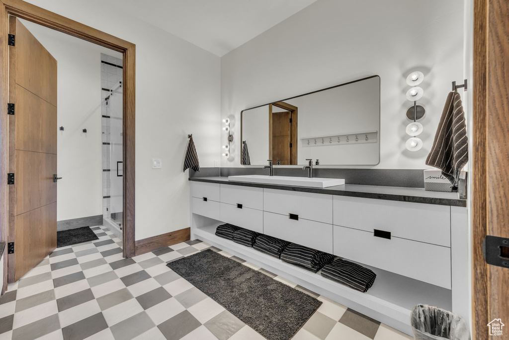 Full bathroom with tile patterned floors, a shower stall, vanity, and baseboards