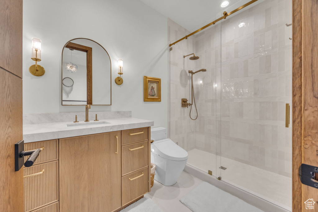 Bathroom with toilet, a stall shower, and vanity