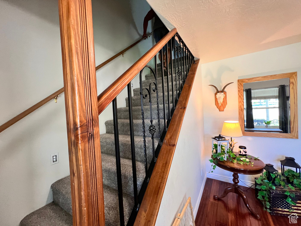 Stairs featuring wood finished floors and baseboards