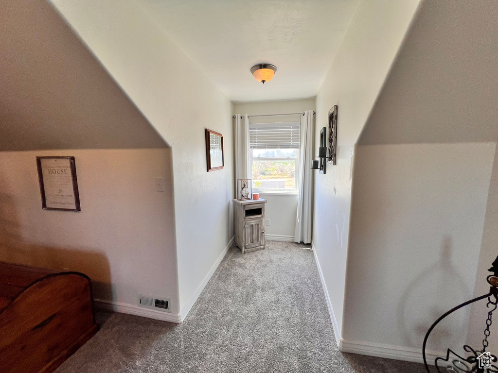 Corridor with carpet flooring and baseboards