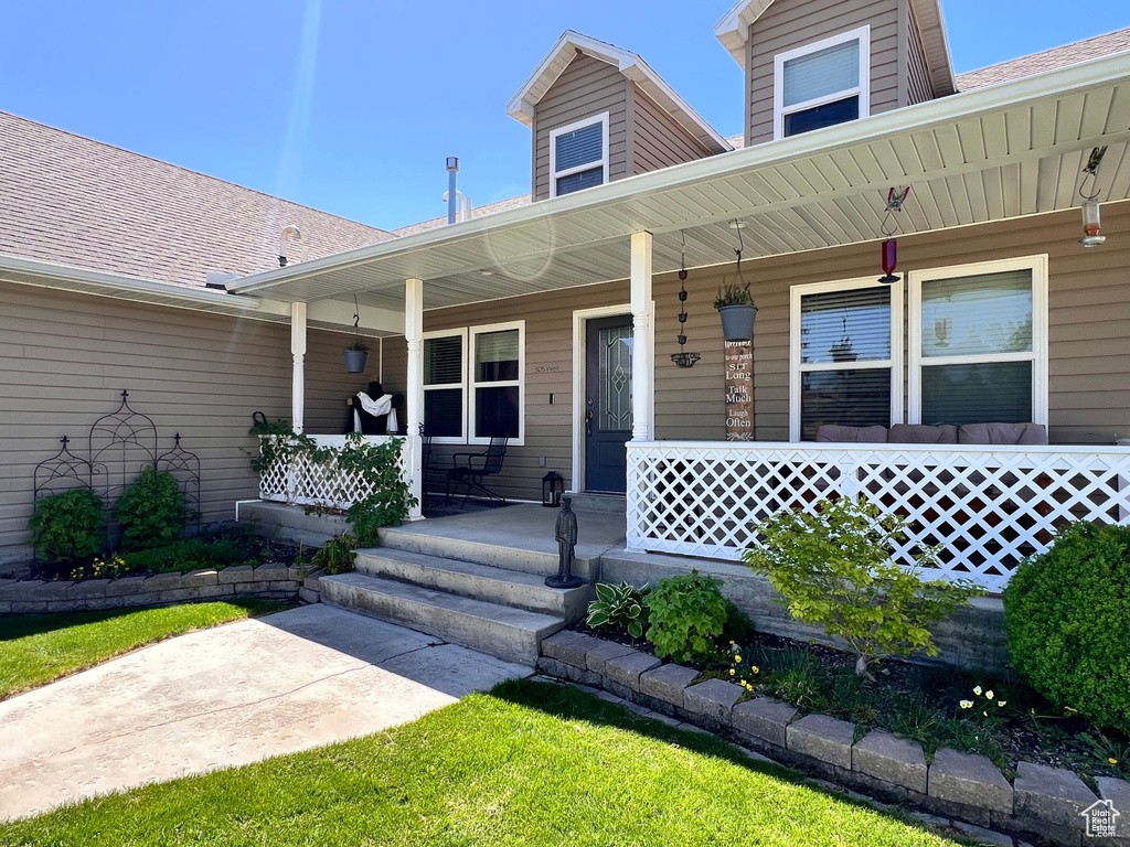 View of front of property featuring covered porch and a shingled roof