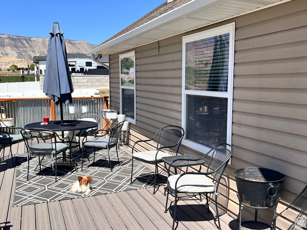 Wooden deck featuring a mountain view and outdoor dining space