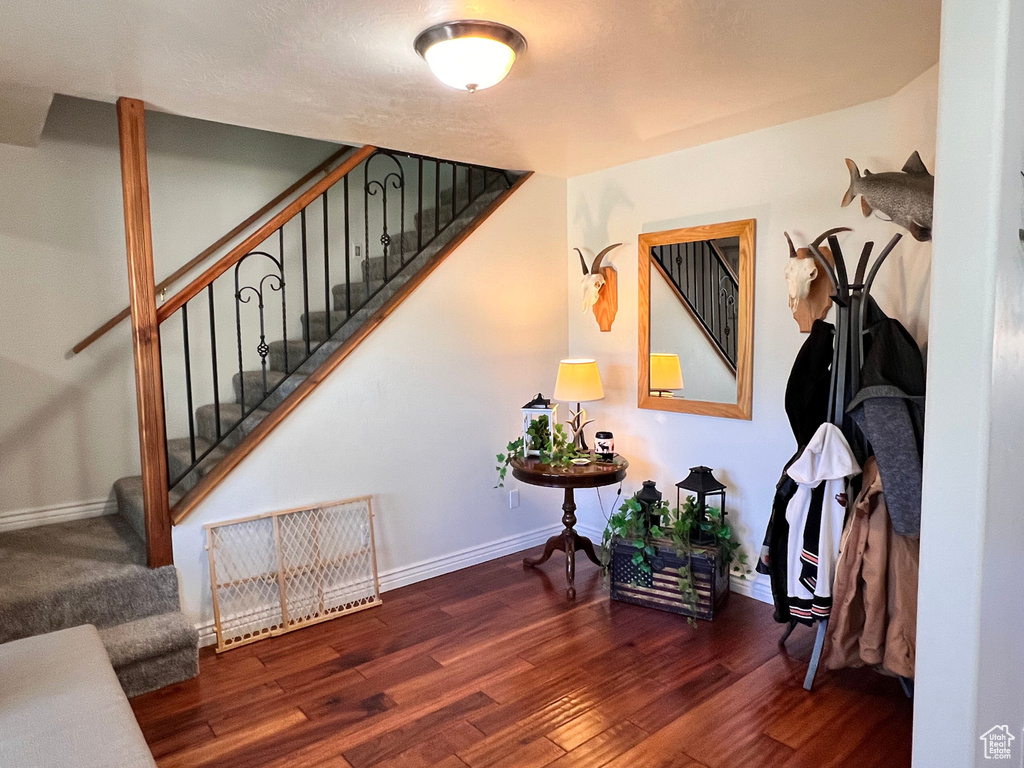 Stairway with wood finished floors and baseboards