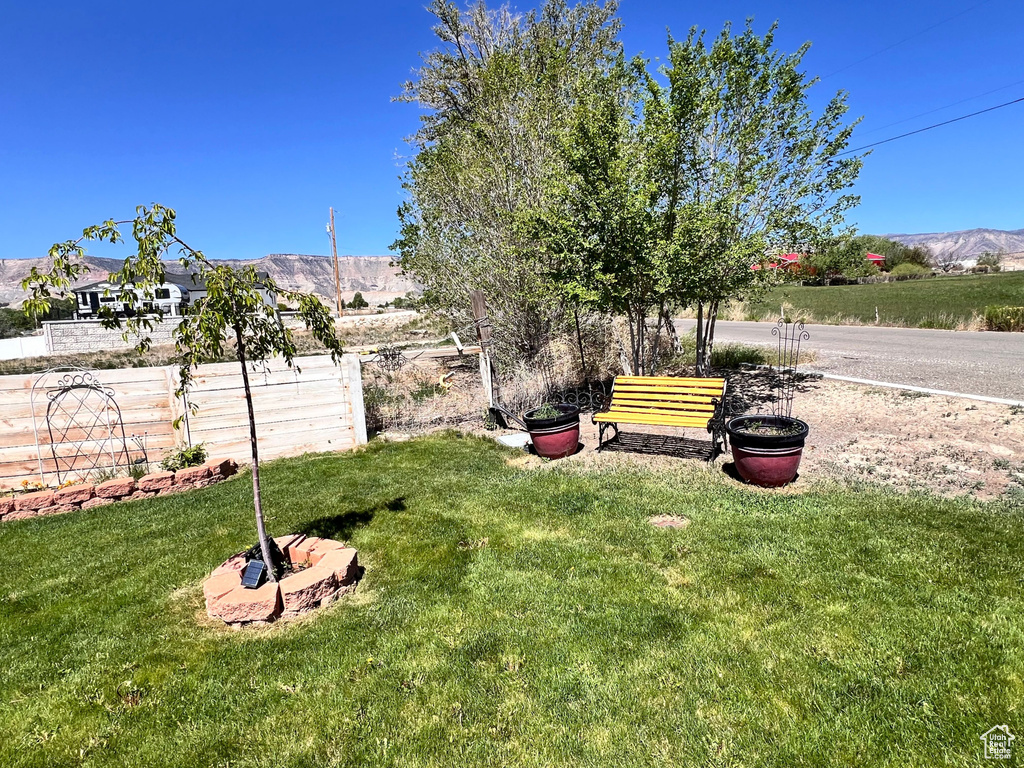 View of grassy yard with a mountain view