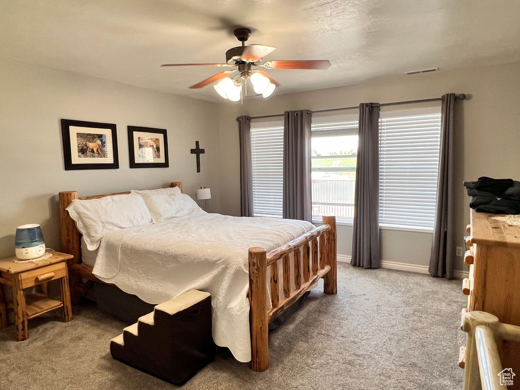 Bedroom featuring light carpet, baseboards, and ceiling fan