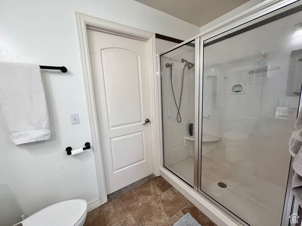 Full bathroom featuring toilet and a shower stall