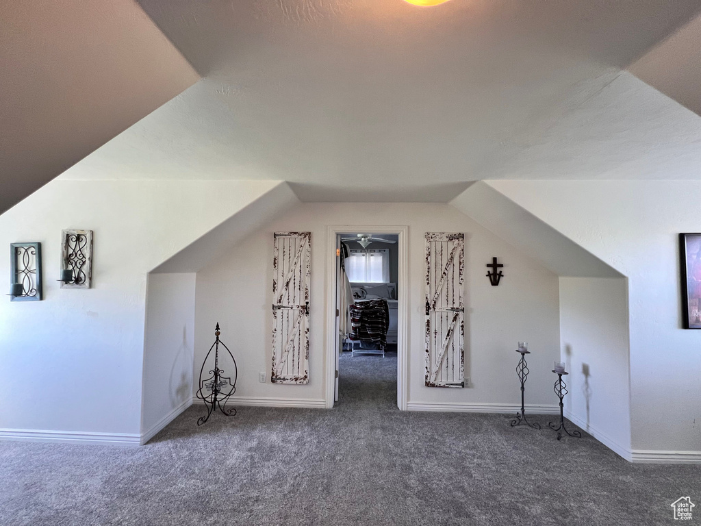 Bonus room featuring carpet floors, lofted ceiling, and baseboards