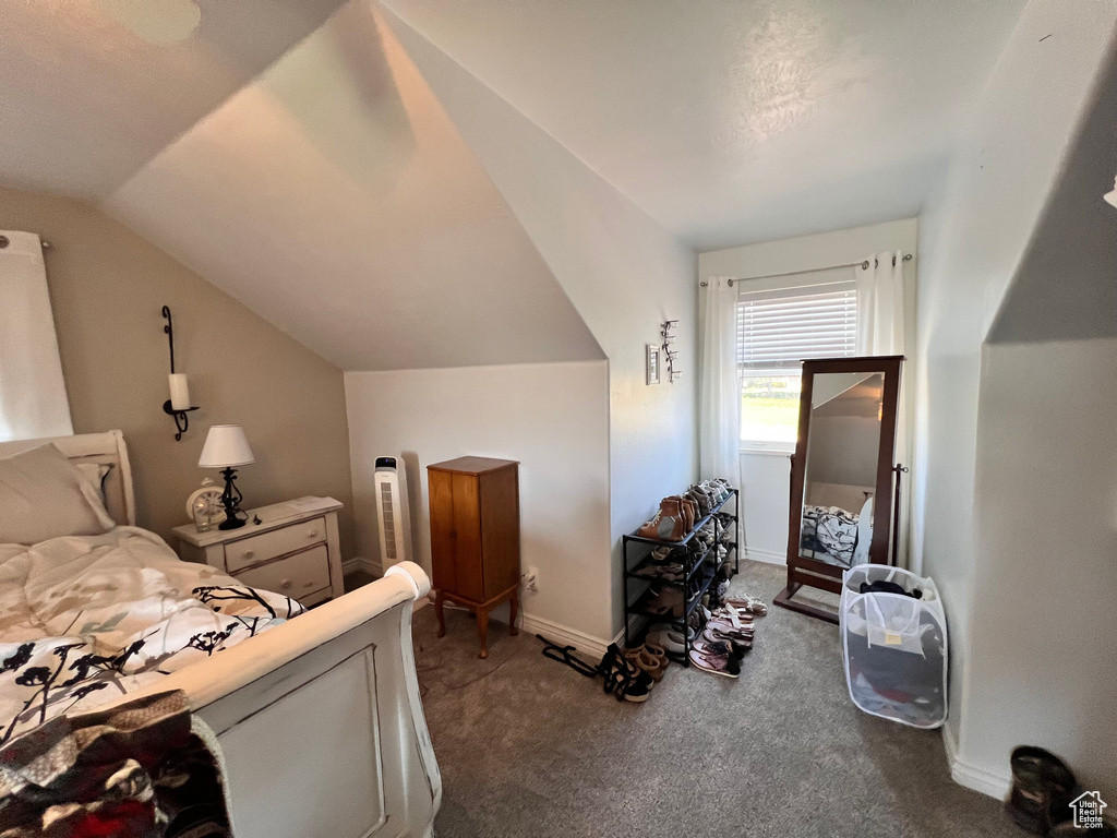 Bedroom with carpet flooring, vaulted ceiling, and baseboards