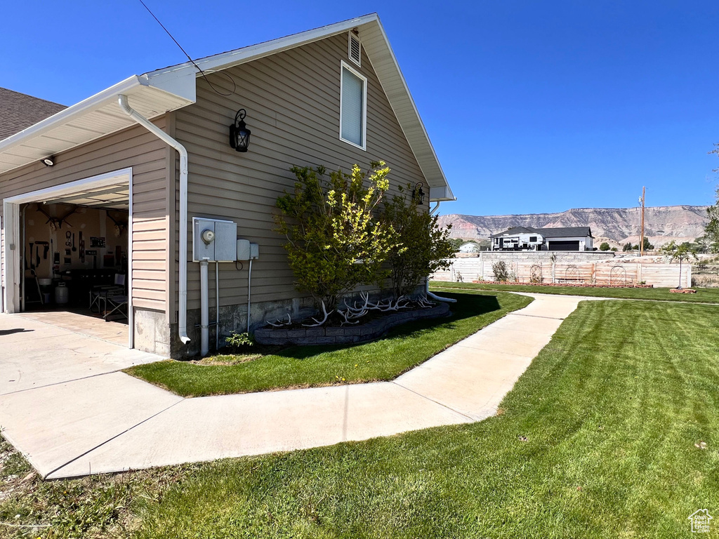 View of side of home with a garage, concrete driveway, and a mountain view