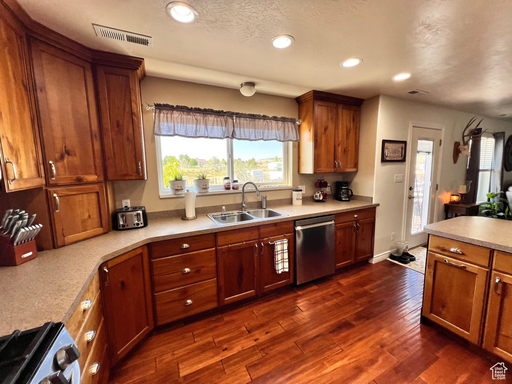 Kitchen with dishwasher, a sink, gas stove, dark wood-type flooring, and recessed lighting