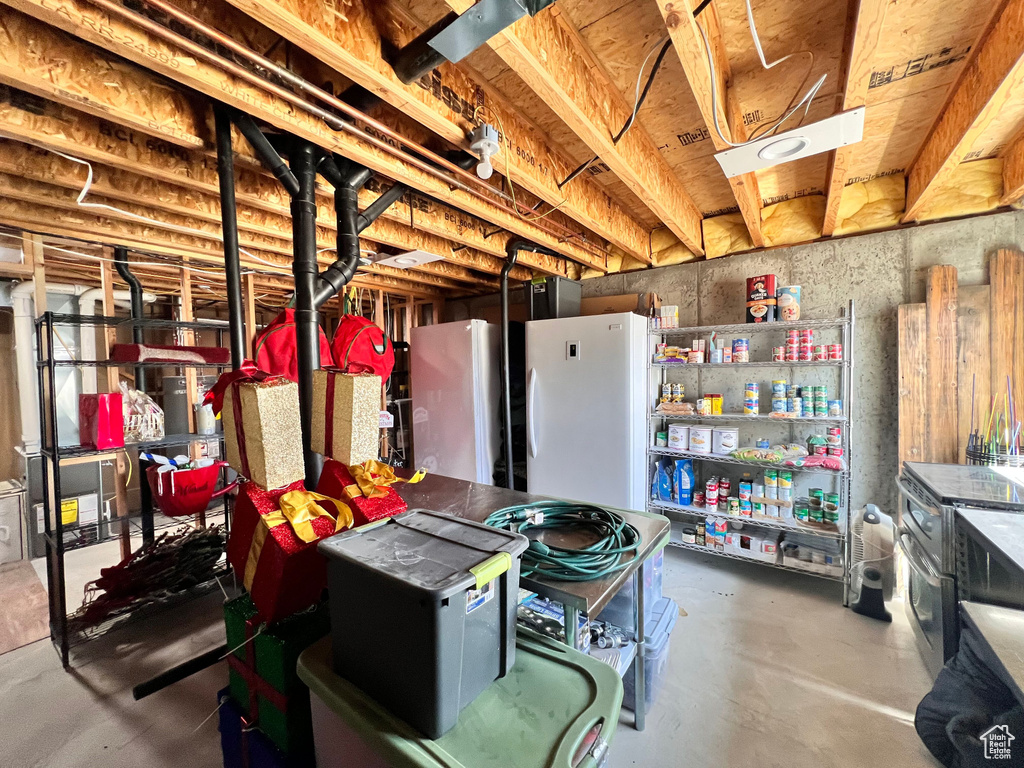 Unfinished below grade area with freestanding refrigerator and fridge