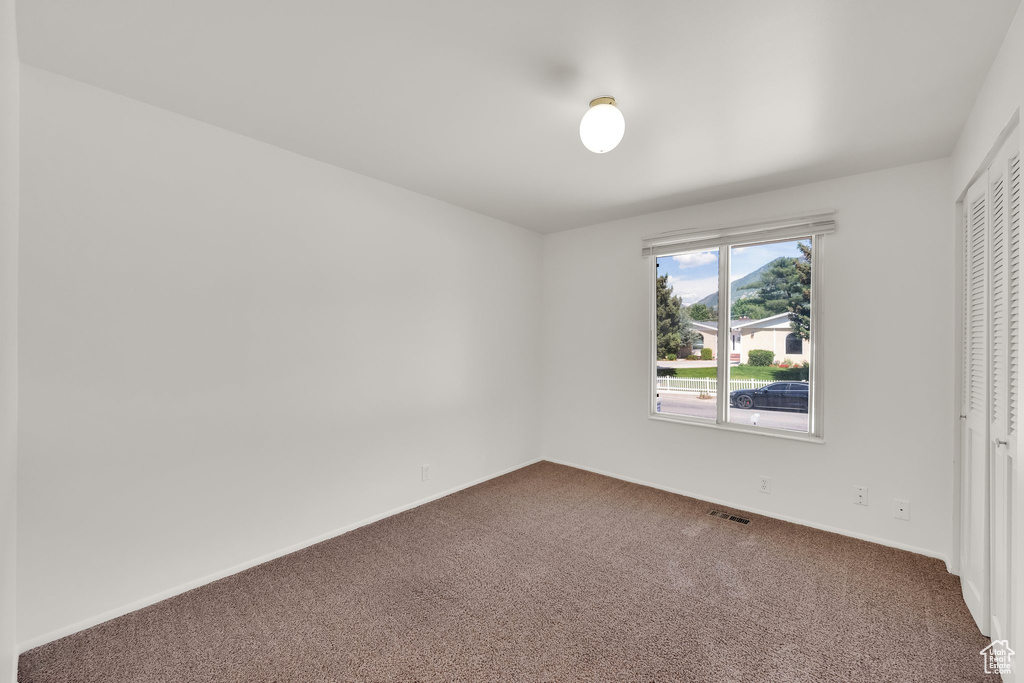 Unfurnished bedroom featuring carpet, baseboards, and a closet