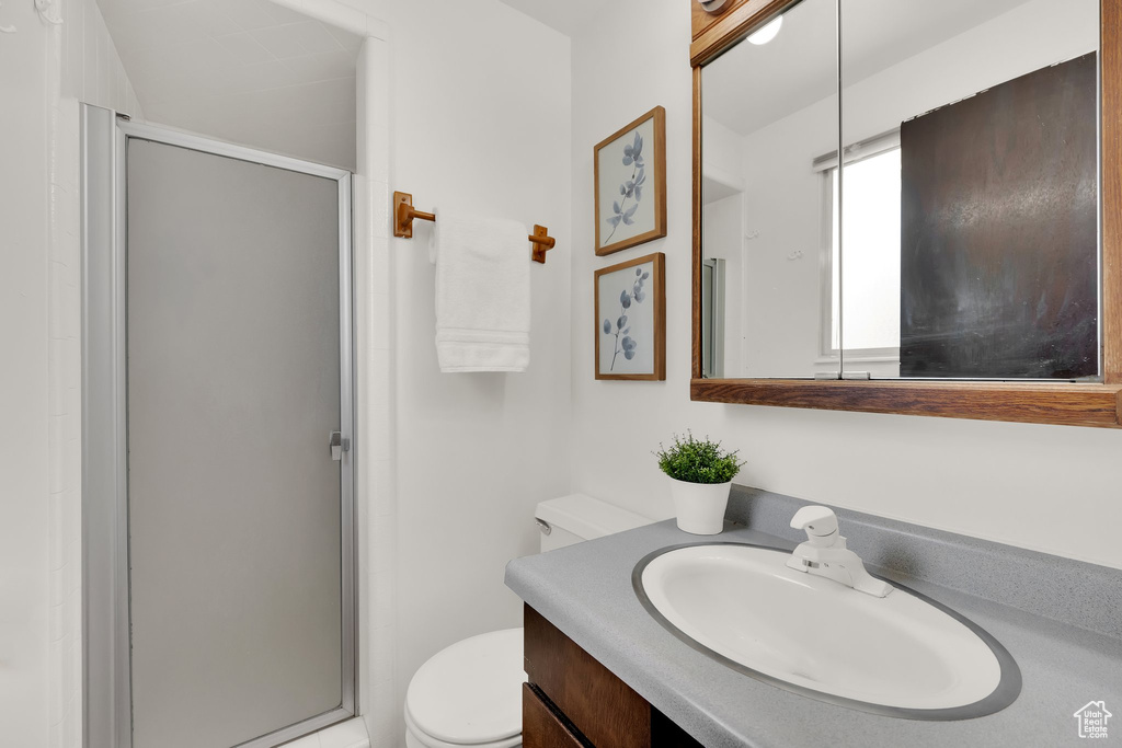 Full bath with vanity, a stall shower, and toilet