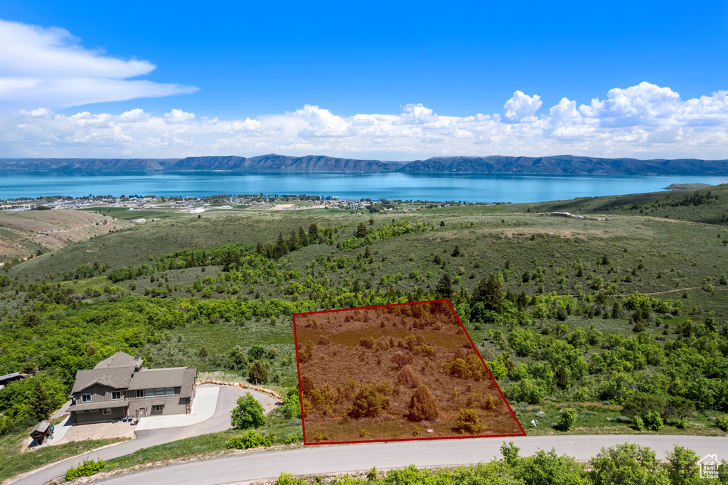 Aerial view of property and surrounding area featuring a water and mountain view and property parcel outlined