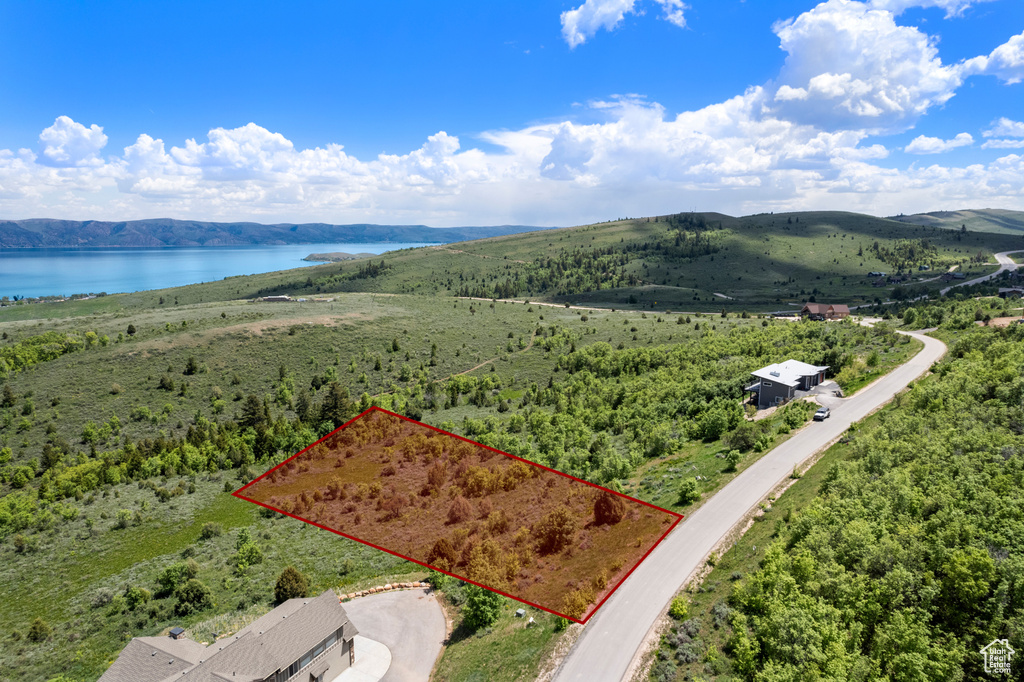 Aerial view of property and surrounding area featuring a water and mountain view and property boundaries highlighted