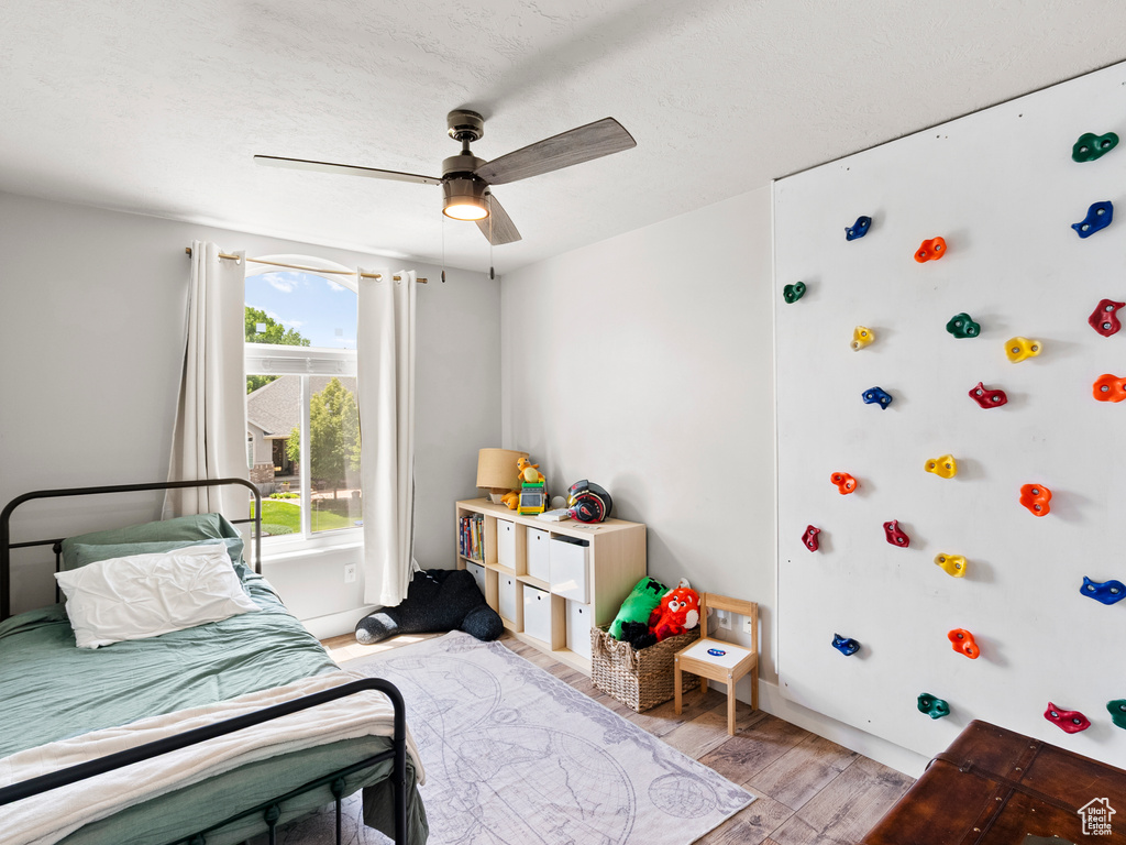 Bedroom featuring light wood-type flooring, baseboards, and a ceiling fan